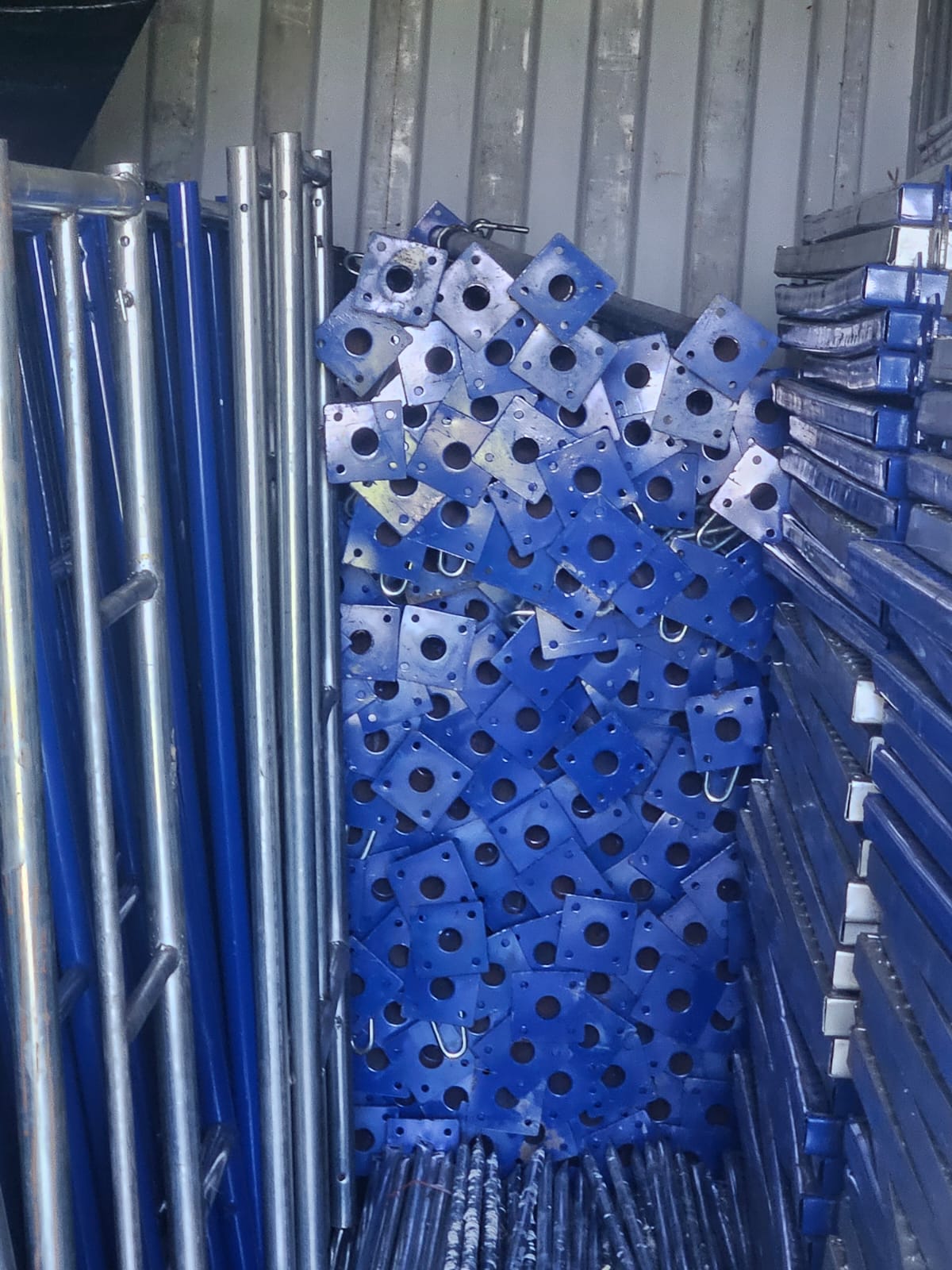 Close view of blue adjustable metal props, base plates, and support components in the KBS rental inventory