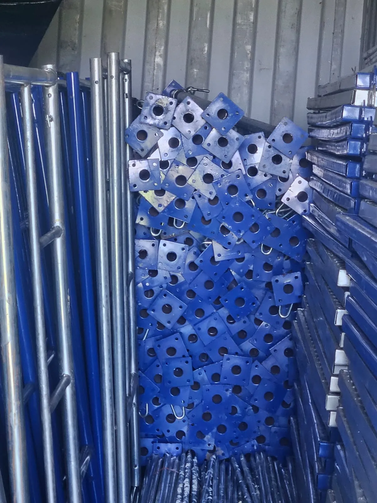 Close view of blue adjustable metal props, base plates, and support components in the KBS rental inventory