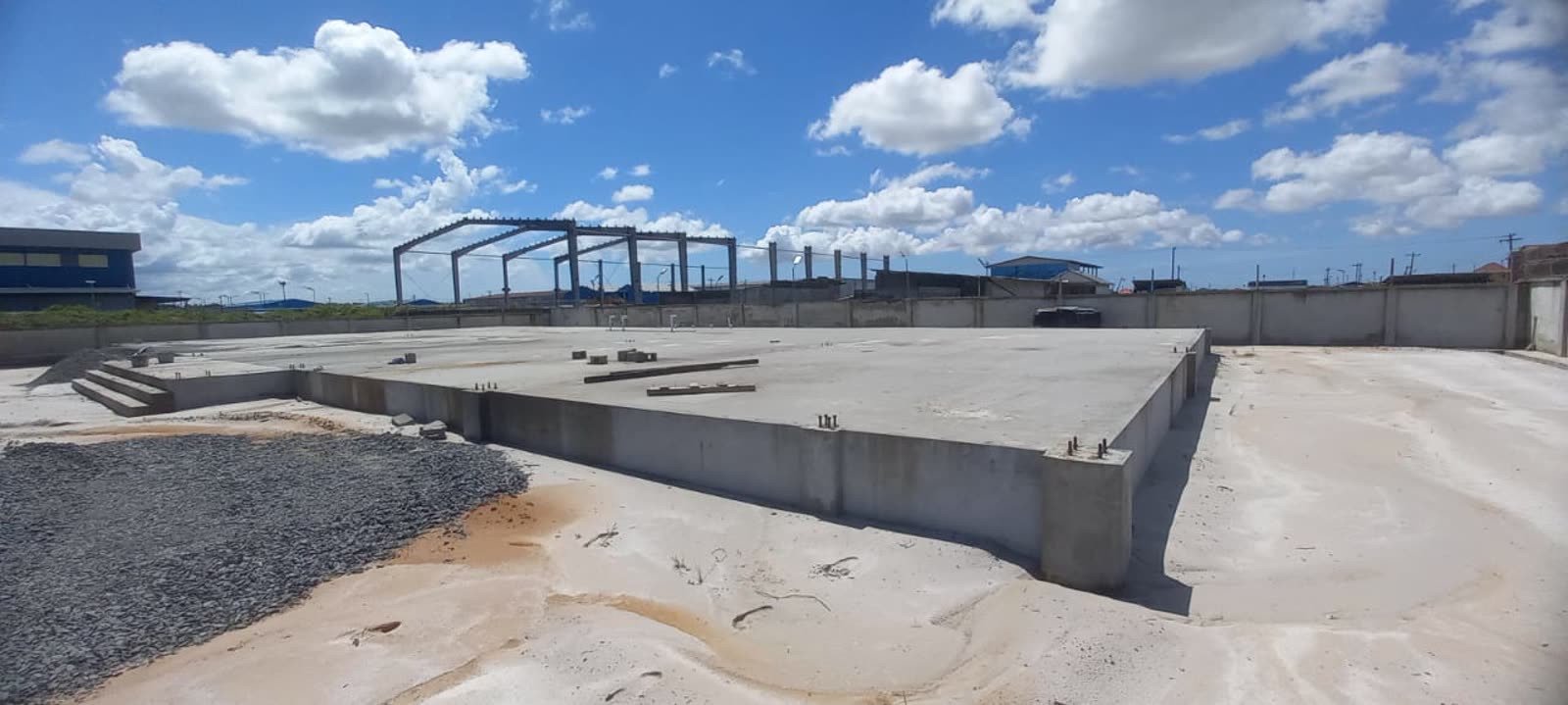 Reinforced concrete curb wall cast around the warehouse slab